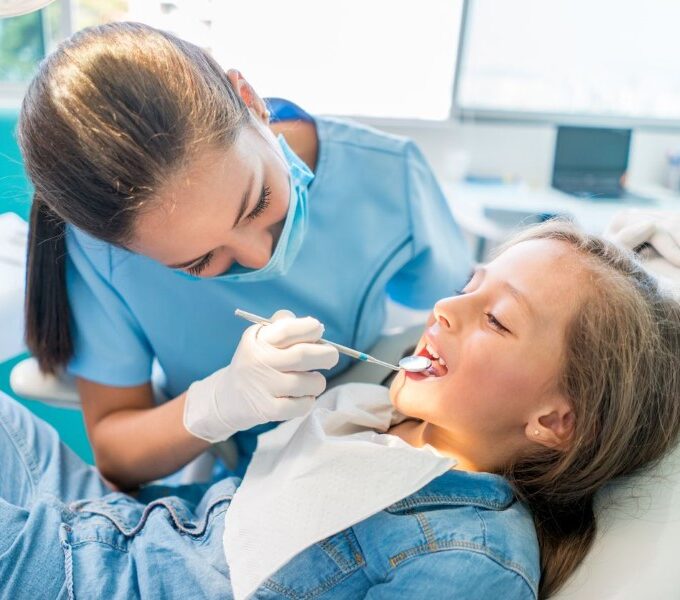 Young girl sitting on dental chair getting her teeth checked by a dentist Live Sv 3 ways family dentistry enhances confidence through smiles